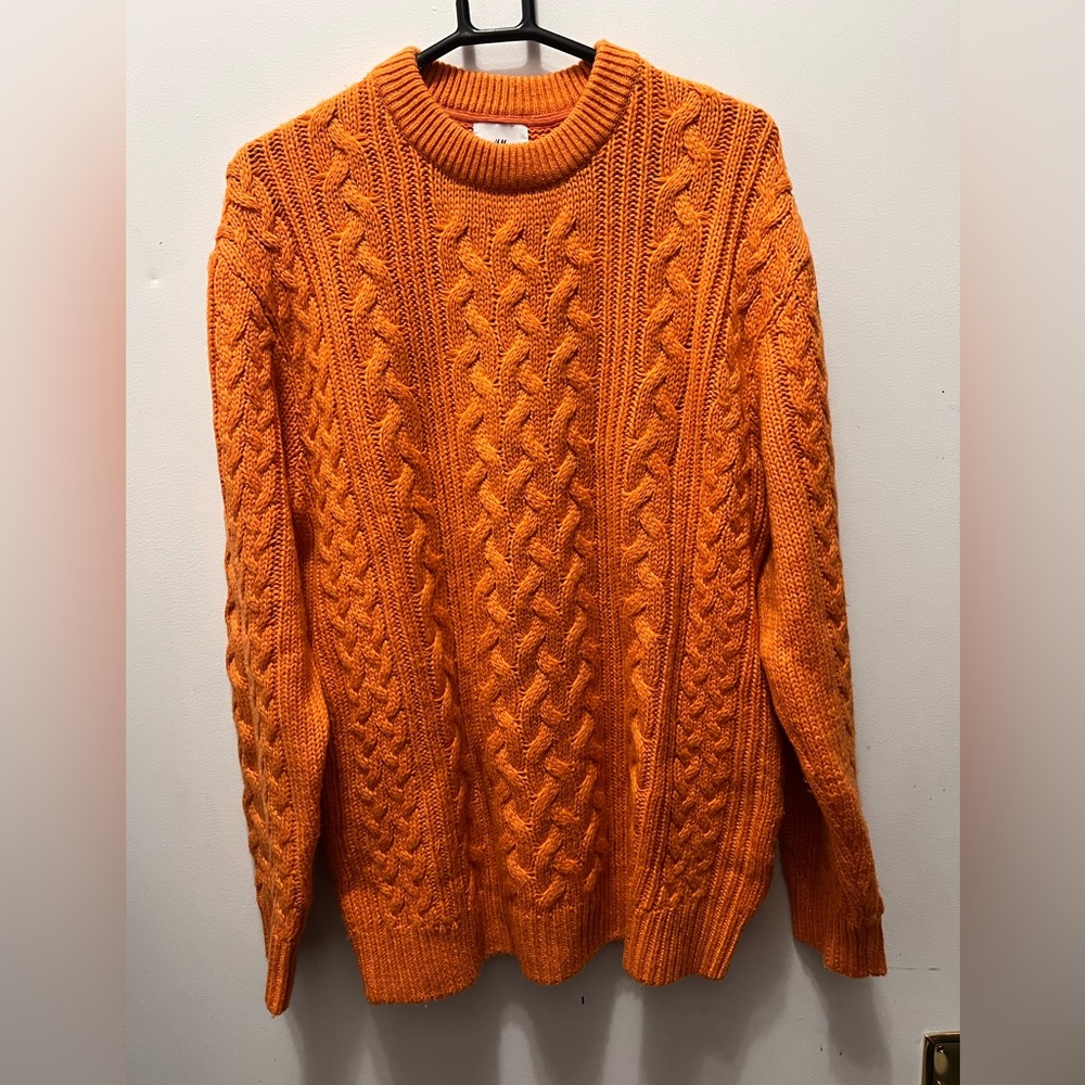 Bright orange thick cableknit sweater.